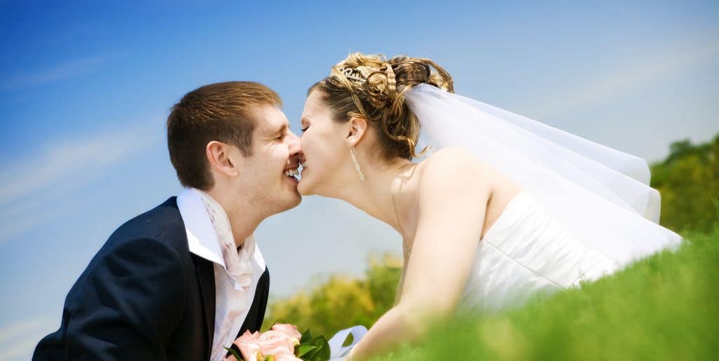Küssendes Brautpaar im Gras