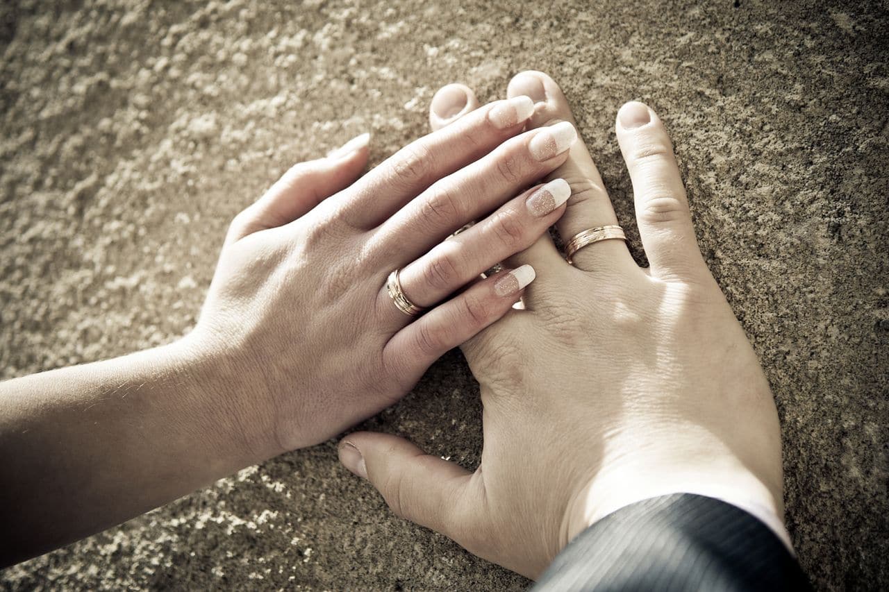 Hände des Brautpaares mit eheringen