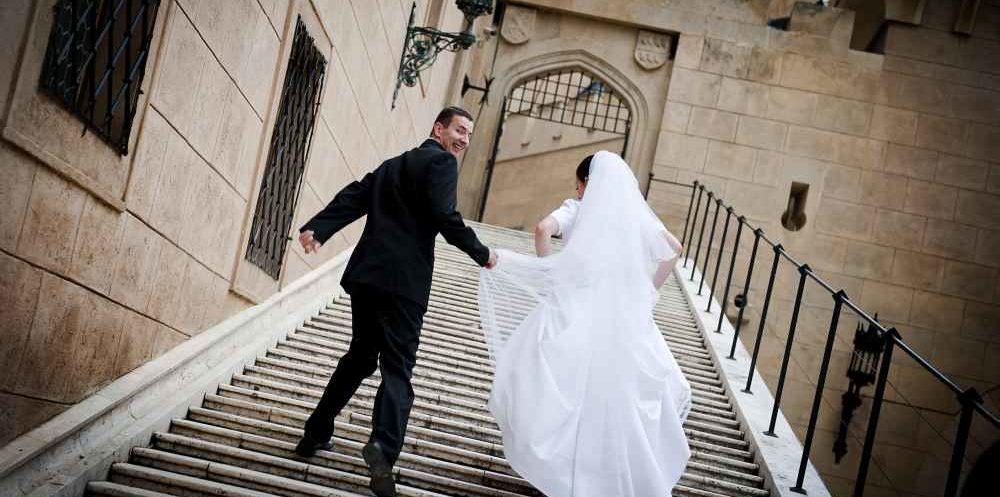 Brautpaar auf der Treppe eines Schlosses